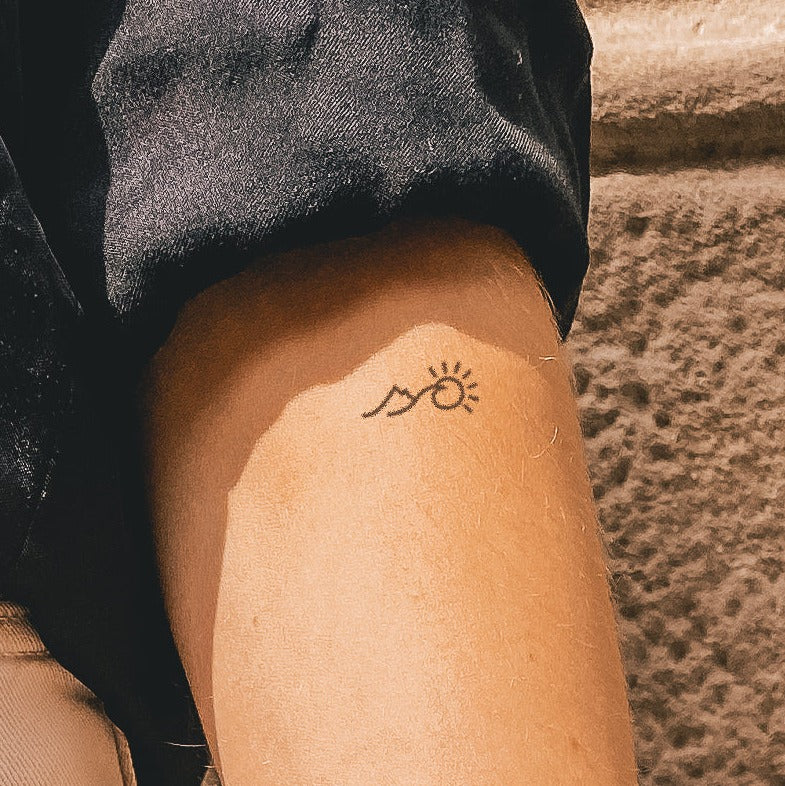 Tatouage montagne, soleil et vague
